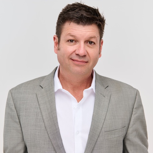 Headshot of a man in a grey blazer and white shirt, photographed in Cedar Park by Ryan Dunbar