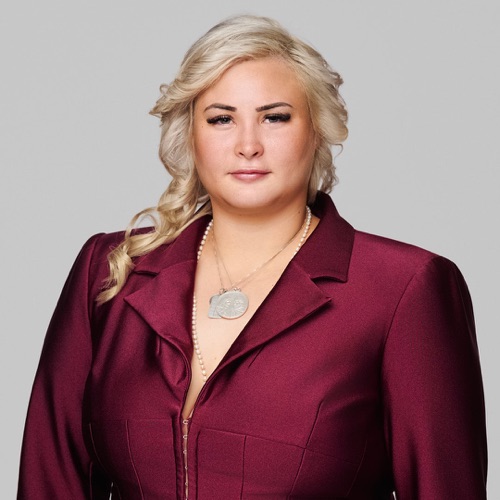 Headshot of a smiling woman with wavy blonde hair in a burgundy blazer, ATX Headshots