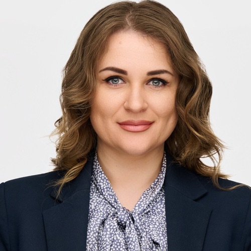 Headshot of a woman in a navy blazer and patterned bow blouse, ATX Headshots