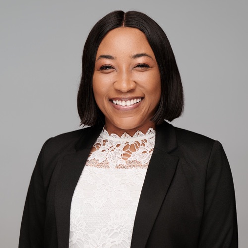 Headshot of a smiling woman in a black blazer and white lace top, ATX Headshots
