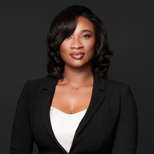 Headshot of a woman in a black blazer against a dark backdrop, ATX Headshots
