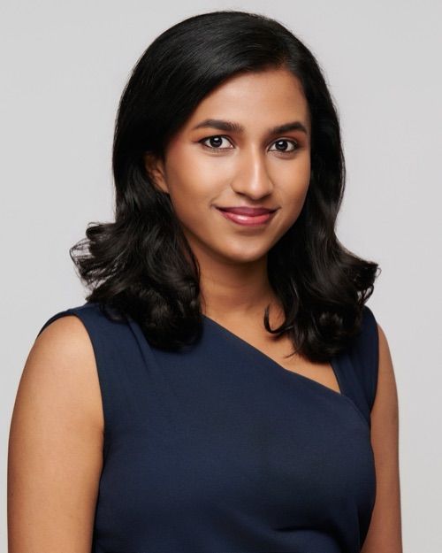 Headshot of a smiling woman with dark hair in a navy top, ATX Headshots