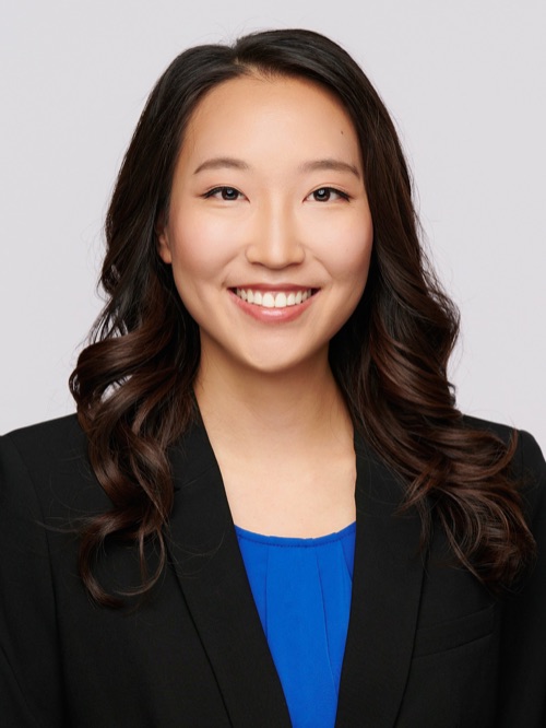 Headshot of a smiling woman in a black blazer and blue top, by Ryan Dunbar at ATX Headshots